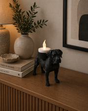 Matte zwarte Presa Canario waxinelichthouder met LED-waxinelichtje op donker houten kastje met decoratie in sfeervolle woonkamer.